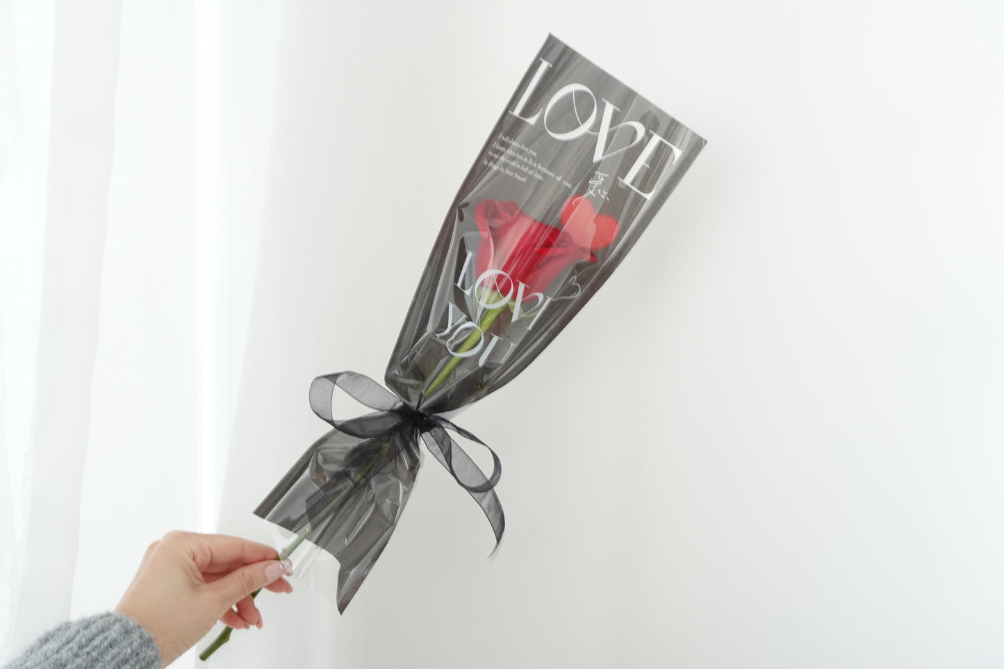 Portrait view of a single premium rose stem wrapped in Bellassom’s signature black wrapping style, perfect heartfelt gift with Vancouver delivery or pick-up