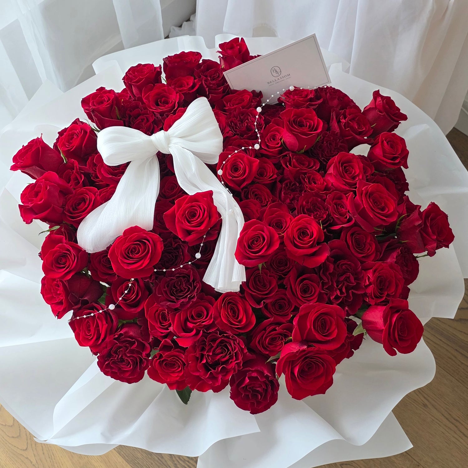 Massive 100 red rose bouquet in Bellassom's exclusive handcrafted fabric wrapping,pearl string and bow decoration.