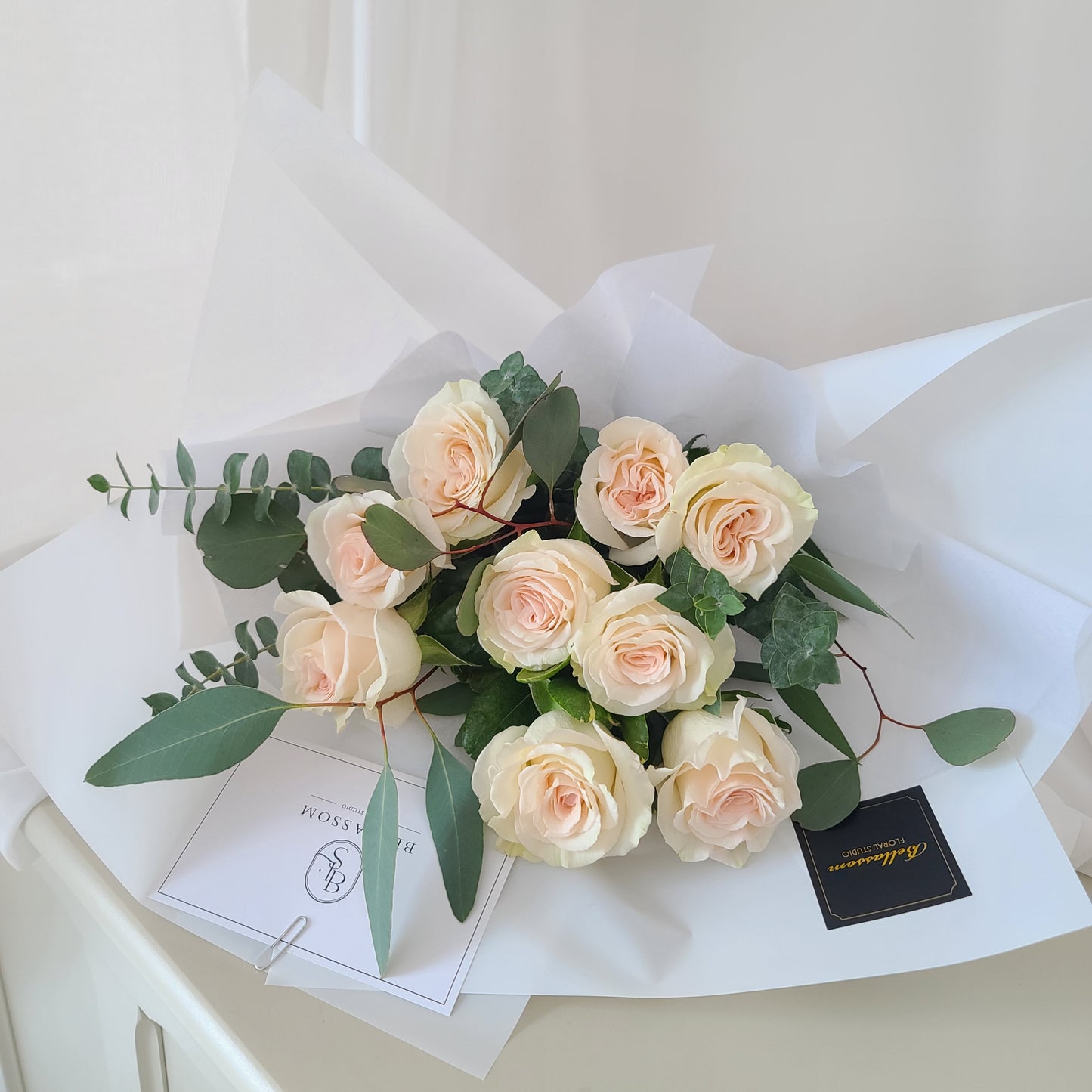 Close-up of premium white roses and eucalyptus in a hand-tied bouquet for birthdays and anniversaries, Vancouver delivery available