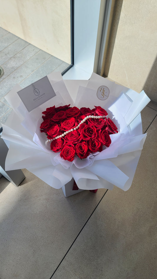 Close-up of 33 red roses in luxury heart-shaped bouquet with delicate pearl string