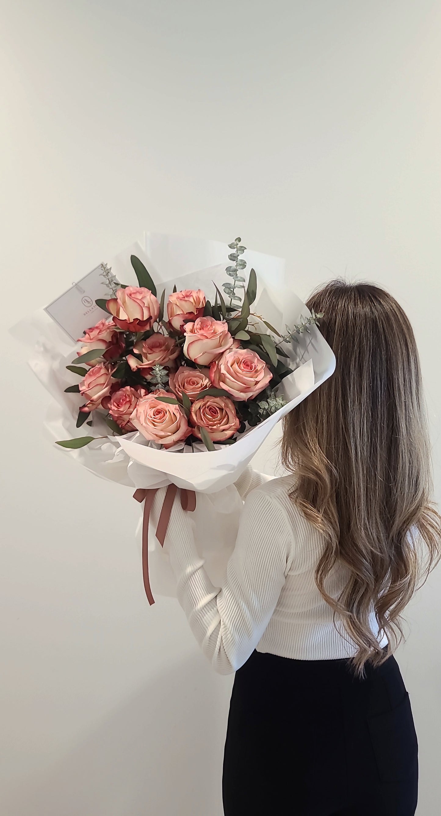 Rosy two-toned rose bouquet accented with eucalyptus in Bellassom’s signature wrap for romantic gifts and same-day delivery in Vancouver